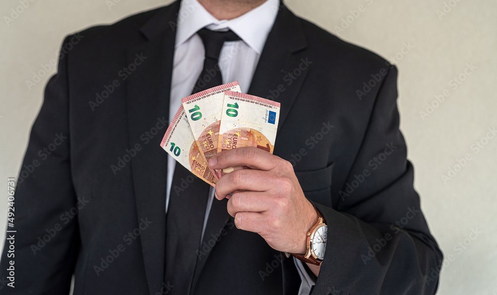 Man in suit holding euro banknotes at business center Man in suit holding euro banknotes at business center