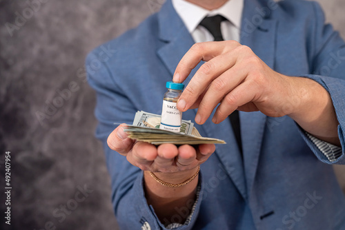 Stylish elderly man in a suit carries the vaccine in a jar and dollars for it.