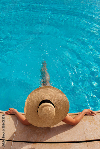 Beautiful woman sunbathing by the pool top view vertical. Summer background. Poster, mock up for design photo