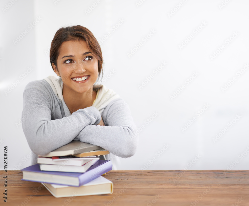 Finding the solution to a problem. Shot of a beautiful college student leaning on her books at her desk and looking thoughtful. Finding the solution to a problem. Shot of a beautiful college student leaning on her books at her desk and looking thoughtful.