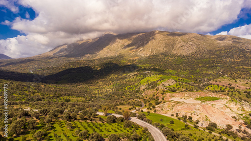 Beautiful and scenic aerial shot of a mountain landscape with clouds in Crete, Greece
