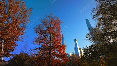 Ultra-luxury high-rise residential skyscraper in Billionaires’s Row, which stands beyond the autumnal leaf color tree in Central Park on November 16, 2021 at New York City NY USA. photo