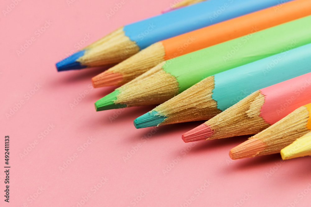 Some colored crayons on pink background. Macro close-up pencil. Selective focus Some colored crayons on pink background. Macro close-up pencil. Selective focus