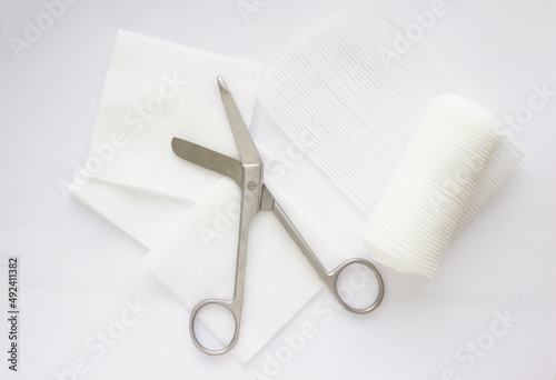 Gauzes, scissors and roll gauze on white background,closed up