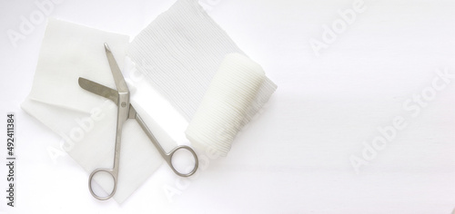 Gauzes, scissors and roll gauze on white background,closed up