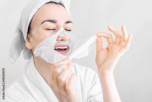 Young woman with sheet mask on her face, spa procedure.