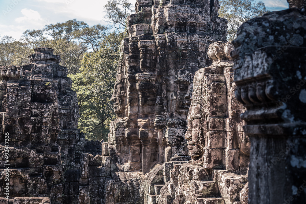 Sacred smiling faces of ancient Khmer kings on temple towers in Angkor complex, Siem Reap, Cambodia