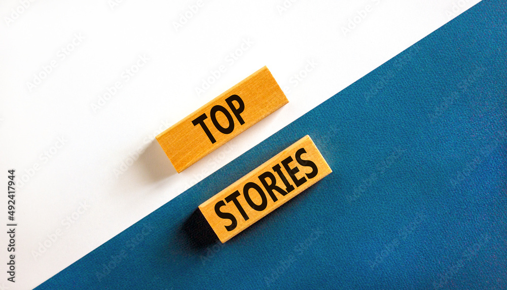 Top stories symbol. Concept words Top stories on wooden blocks on a beautiful blue table white background. Business story and top stories concept, copy space. - obrazy, fototapety, plakaty 