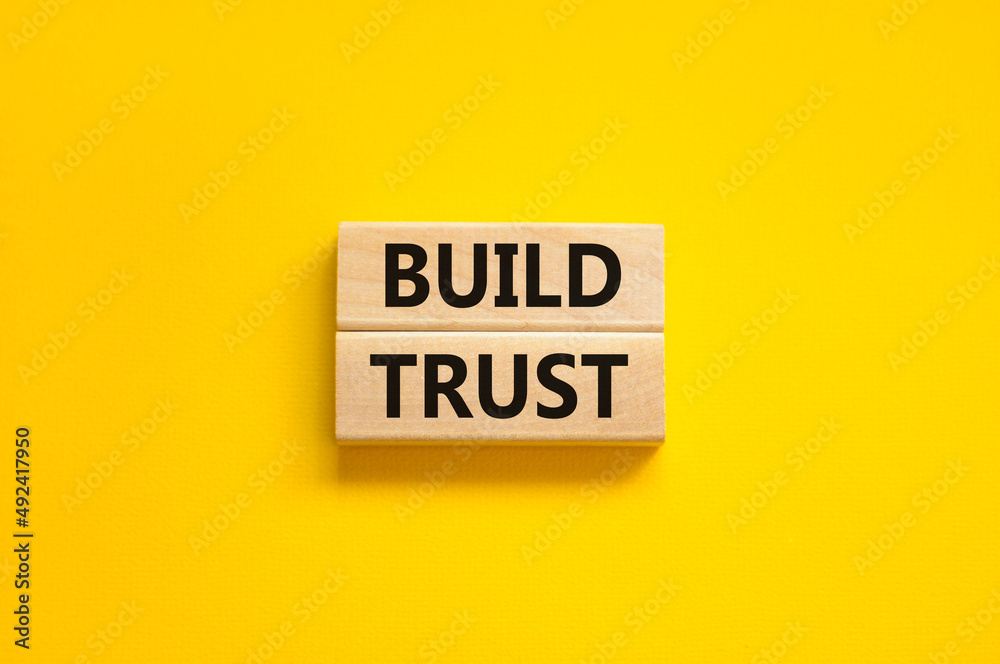 Build trust symbol. Concept words Build trust on wooden blocks on a beautiful yellow table yellow background. Business and build trust concept, copy space. Build trust symbol. Concept words Build trust on wooden blocks on a beautiful yellow table yellow background. Business and build trust concept, copy space.