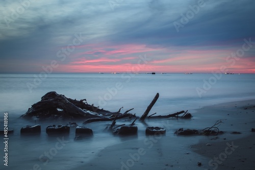 Wonderful colorful seaside landscape. Wooden beams against the background of the blurred sea. © shadowmoon30