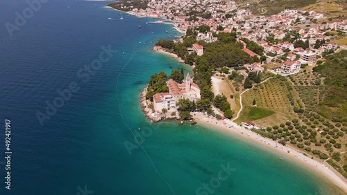 Croatia, Brac island, Bol. Panoramic aerial view of Dominician monastery and pebble beach on Adriatic sea. 4k drone video. Summer vacation resort photo