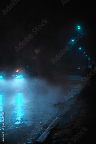 night road in the fog with car headlights