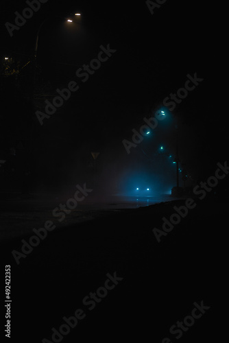 night road in the fog with car headlights