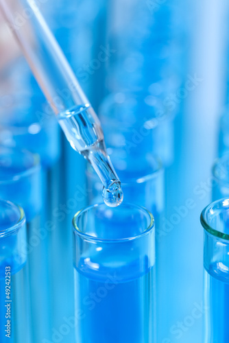 Dripping reagent into test tube with blue liquid, closeup. Laboratory analysis