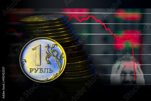 Russian Ruble Coins with falling Stack. Ukrainian flag colors illuminating. Ukraine war sanctions exchange rate ruble fall concept. Macro