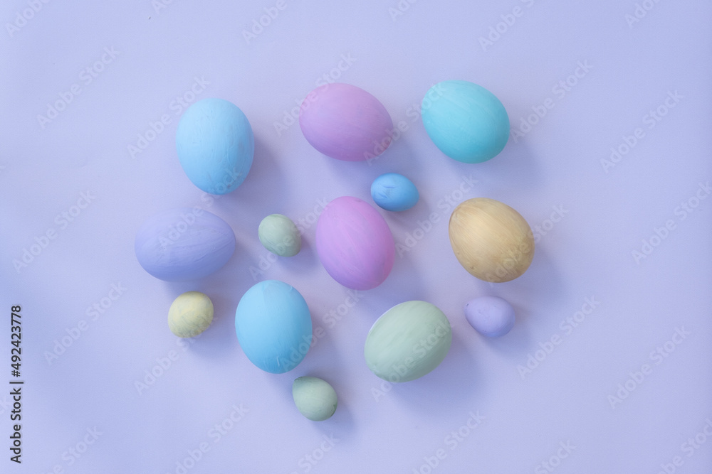 Background for Easter. Easter eggs are laid out on a gentle blue background. Chicken eggs and quail eggs. The eggs are painted in delicate pastel shades. Postcard, background for Easter