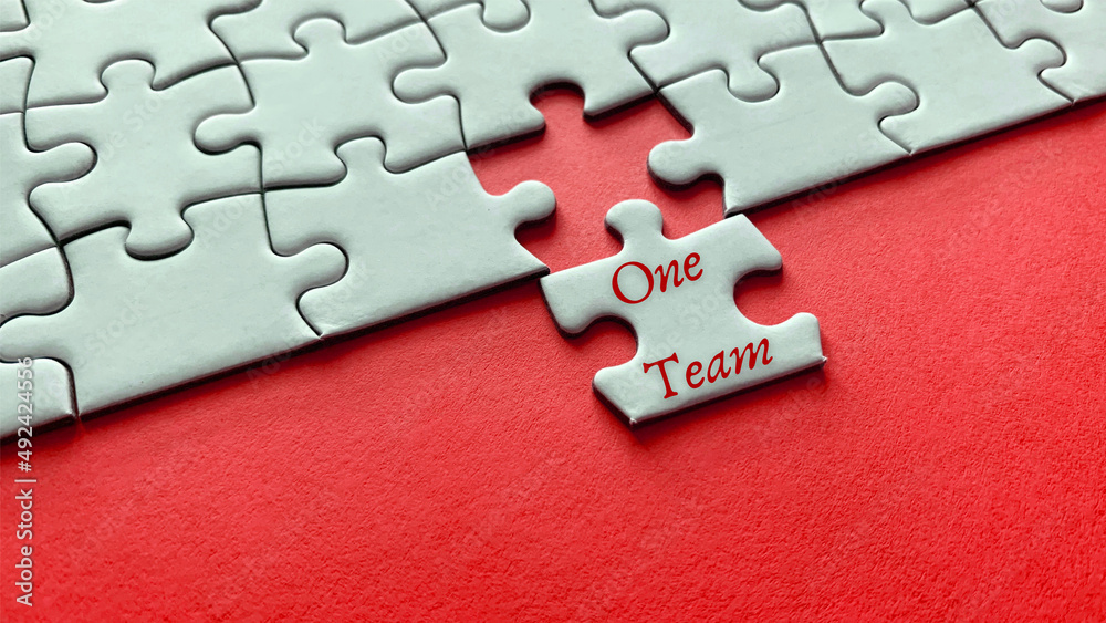 Obraz premium Motivational and inspirational quote on missing jigsaw puzzle - One Team.
