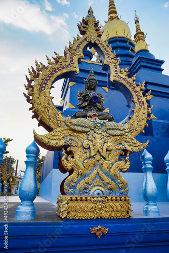 Black buddha statue holding a blue crystal ball inside a Rong Suea Ten temple in Thailand.  blue temple .