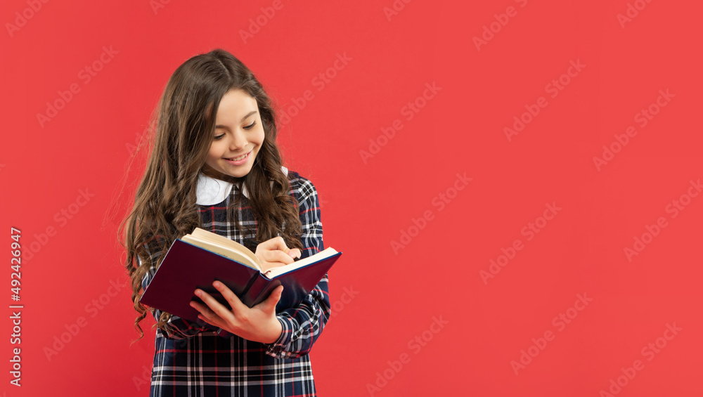 cheerful child making notes on red background with copy space, school cheerful child making notes on red background with copy space, school