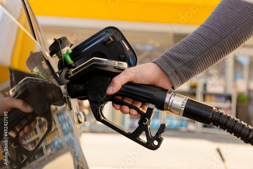 Car refuelling on the petrol station. Man refilling the car with fuel. Close up view. Gasoline, diesel is getting more expensive. Petrol industry and service. Petrol price and oil crisis concept. photo