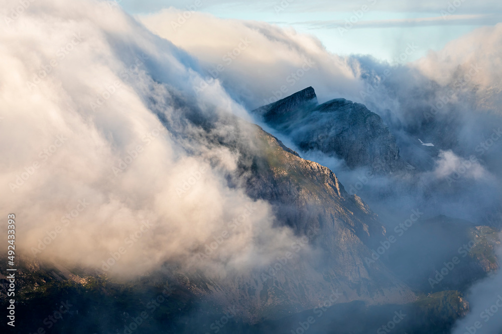 mountain peaks in clouds and sunshine