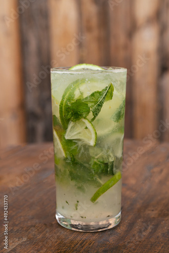 Cocktails. Closeup view of a mojito drink with rum, lime and mint leaves on the wooden table. 