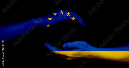 Europe union and Ukraine flags and hands on black background, peace and NATO concept
