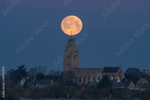 Wolf Moon setting over St Andrew's Chrurch, Sutton-in-the-Isle, Cambridgeshire, 17th January 2022 photo