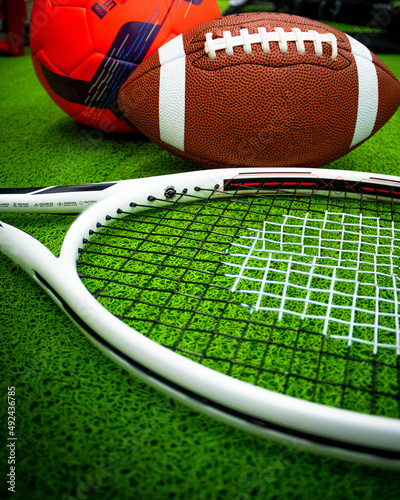 objetos de deporte, raqueta de tenis, balón de Football, y balón pie, aislados en fondo verde photo
