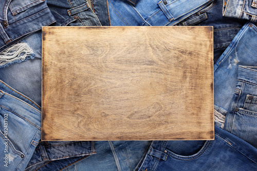 Fotografija Stack of blue jeans denim and wood name plate
