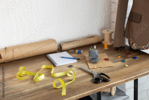 Thread spool with sewing tools on table. Concept of clothes atelier