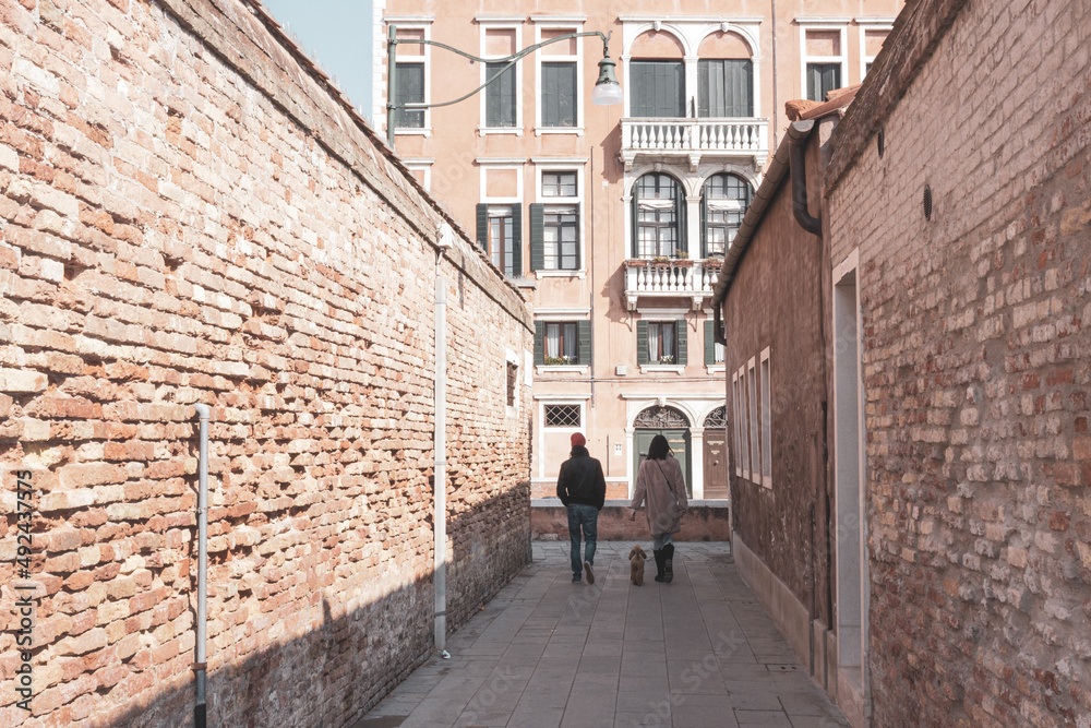 Small Venetian alley with two passers-by.