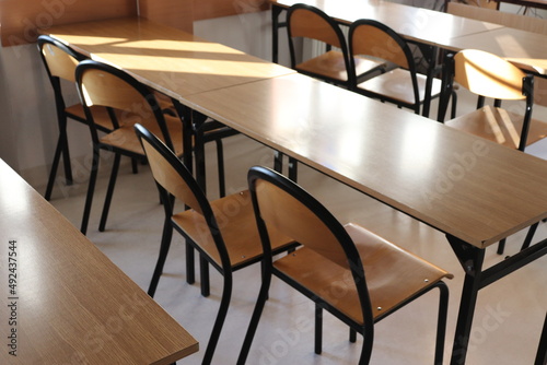 Klasa szkolna z ławkami i krzesłami dla uczniów. 