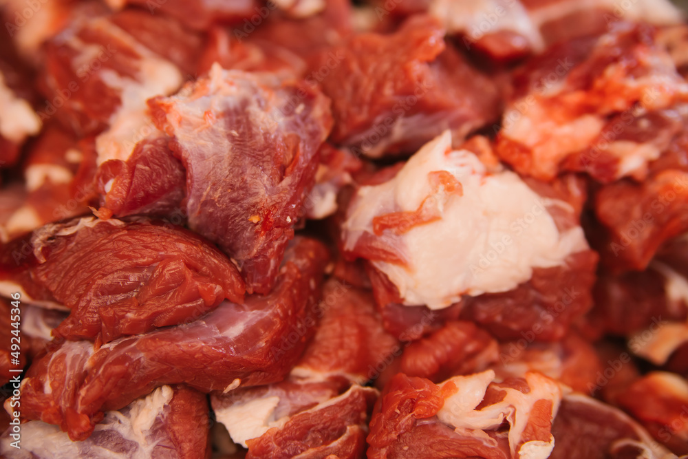 A slide of raw meat cut into pieces. Fresh beef. Preparation for cooking.