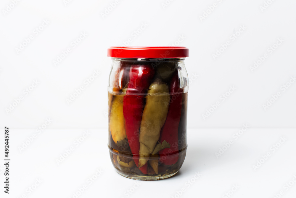 Jar of homemade canned chilli peppers isolated on white background. Jar of homemade canned chilli peppers isolated on white background.