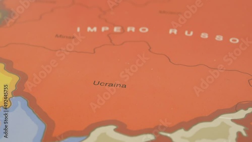 Geographic map illustrating the Russian and Ukrainian borders, Russian tanks attack Ukrainian territory, but hand sweeps them away, putting a peace flag in its place. photo
