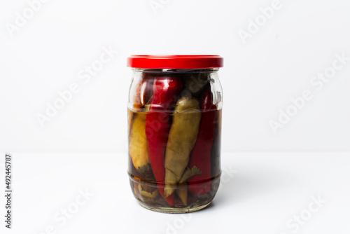 Jar of homemade canned chilli peppers isolated on  white background.