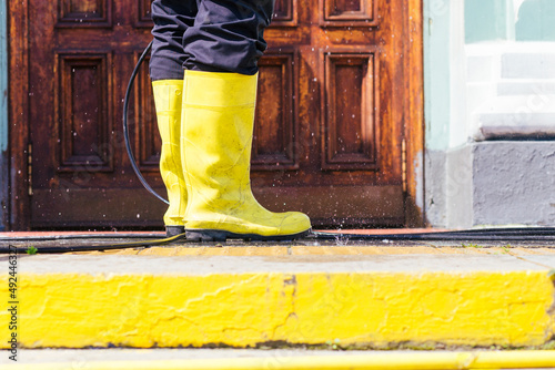a washer in yellow boots , boots close-up on the steps