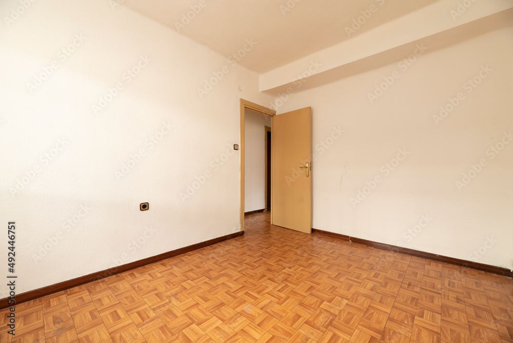 empty room with simil sintasol oak wood floor, yellow painted walls and plain painted door empty room with simil sintasol oak wood floor, yellow painted walls and plain painted door