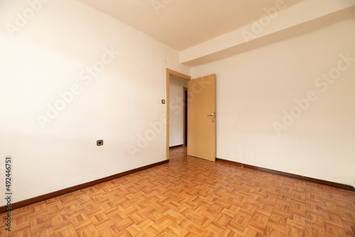 empty room with simil sintasol oak wood floor  yellow painted walls and plain painted door