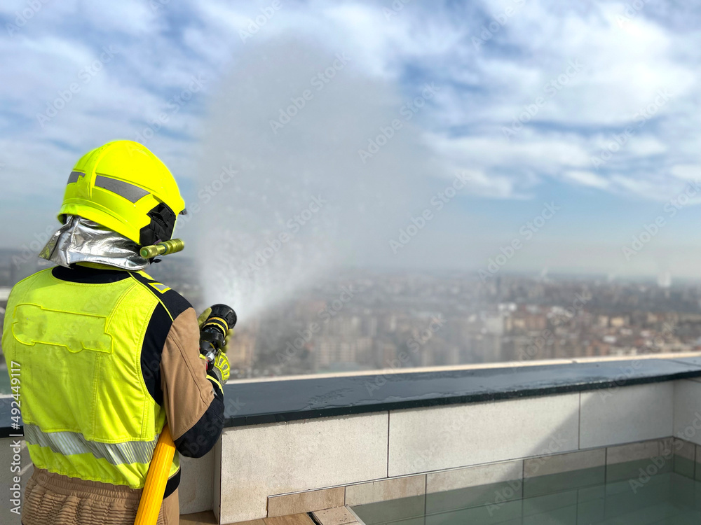 Fototapeta premium firefighter spraying water fire fighting operation