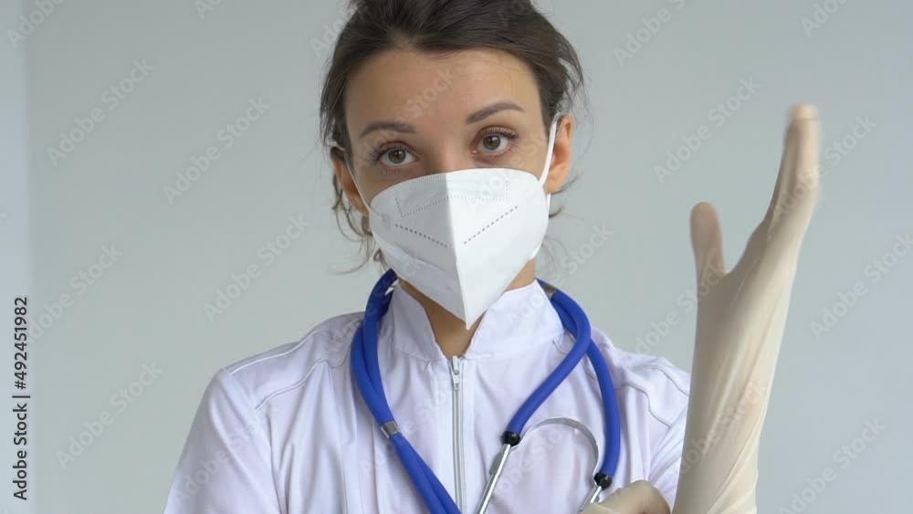 Female doctor is putting off protective blue gloves isolated on white background after some medical manipulations, vaccination. Female doctor is putting off protective blue gloves isolated on white background after some medical manipulations, vaccination.