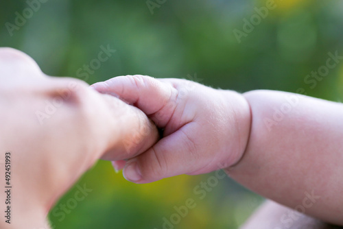 The mother is holding the hand of the child. Mother's and child hands. Family concept © FATIR29