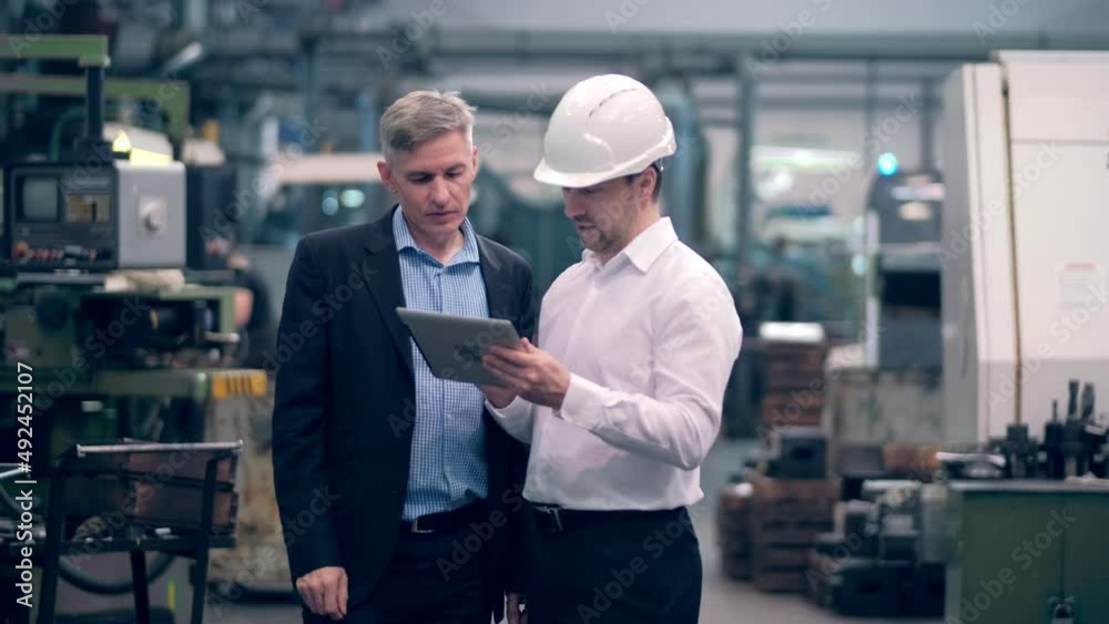Two engineers at an industrial plant. Two workers control the work at the factory. Manufacture of cutting tools. Drill manufacturing plant. Two engineers at an industrial plant. Two workers control the work at the factory. Manufacture of cutting tools. Drill manufacturing plant.