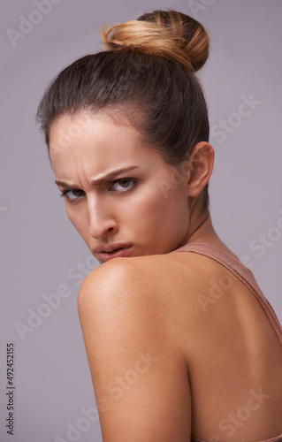 Keeping an eye on things. An attractive young woman against a purple background.