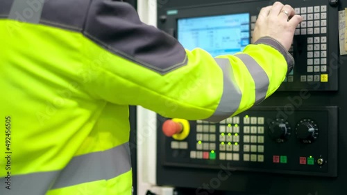 Close-up. The hand presses the buttons on the control panel of the CNC machine. Factory cnc milling machines