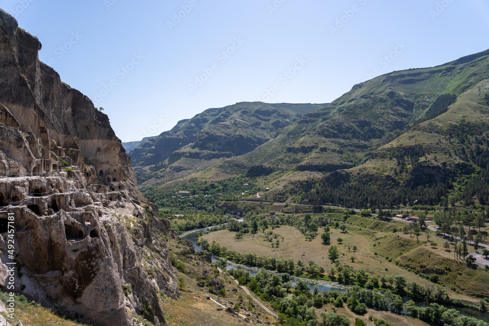 Fototapeta premium monastery in the mountains of georgia where there are caves and passages along the mountain, above them there is a blue sky.