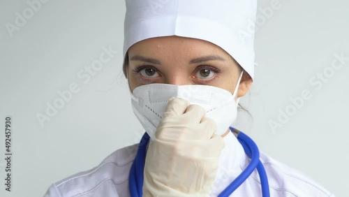 Female doctor is putting off protective blue gloves isolated on white background after some medical manipulations, vaccination.