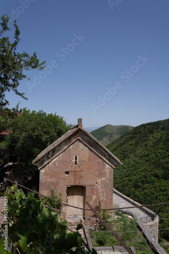 stone building with small wooden doors, behind this building overlooks the beautiful mountains