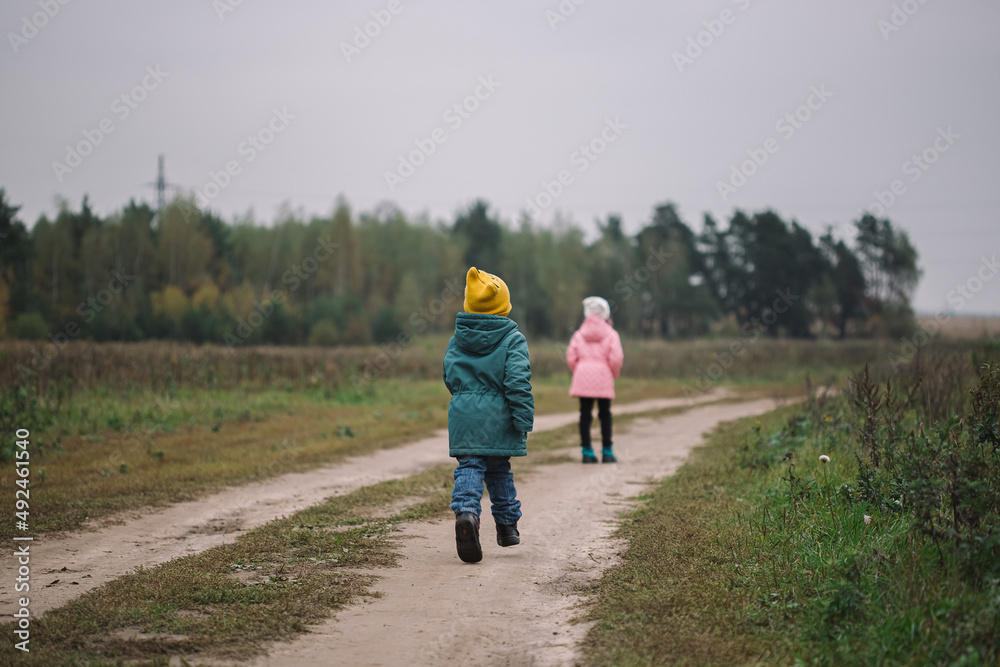 Children play in the field running from flying drone Children play in the field running from flying drone